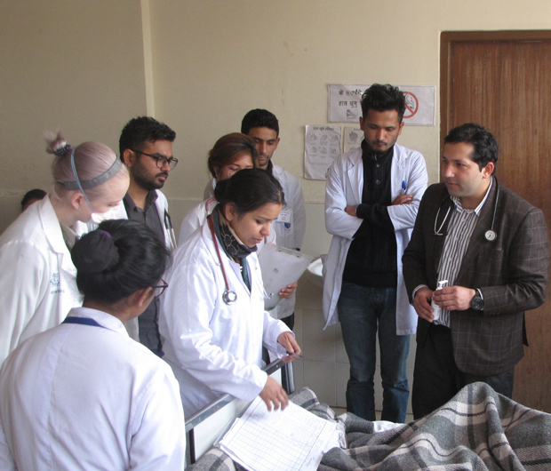 Lecturer Dr Ramesh Kandel MD center in brown jacket leads medicine ward rounds at Patan Hospital in Kathmandu Nepal Photo courtesy of Mark Zimmerman MD