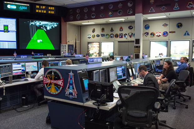 Inside the Mission Control Centers space station flight control room Expedition 41 flight director Chris Edelen and NASA astronaut Serena M Aunon-Chancellor MD FACP spacecraft comm